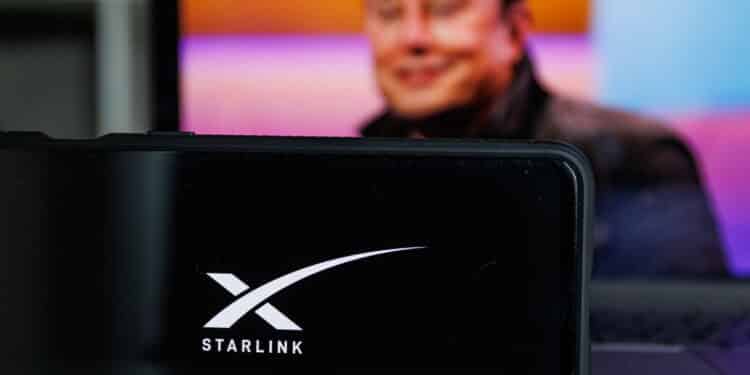 Kaunas, Lithuania - 14 October 2022: Starlink logo on screen and Elon Musk in background