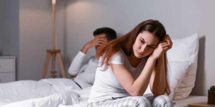 Upset young woman after quarrel with her husband in bedroom