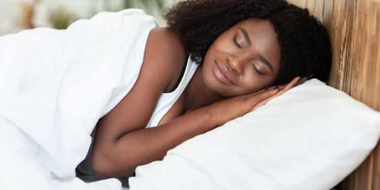 Young beautiful black woman sleeping in her bed