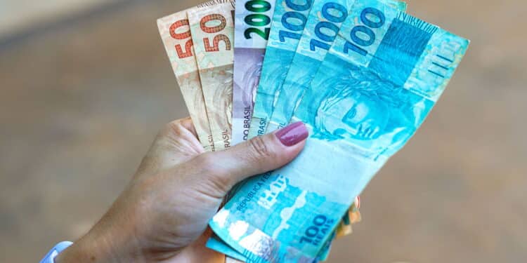 April 19, 2024, Brazil. Woman holds some fifty, one hundred and two hundred reais notes, Brazilian money